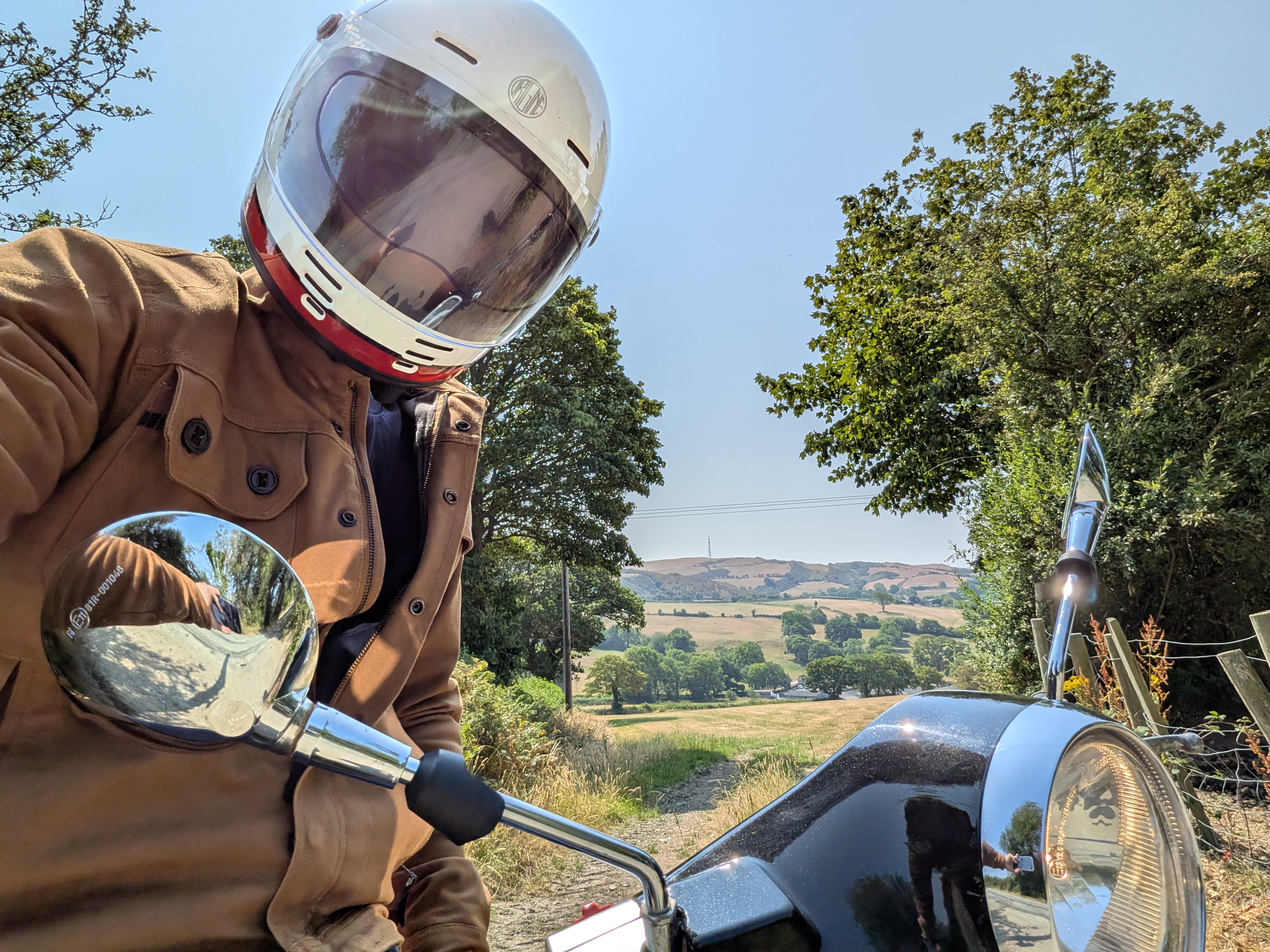 Helmet selfie on the Vespa with Welsh hills behind